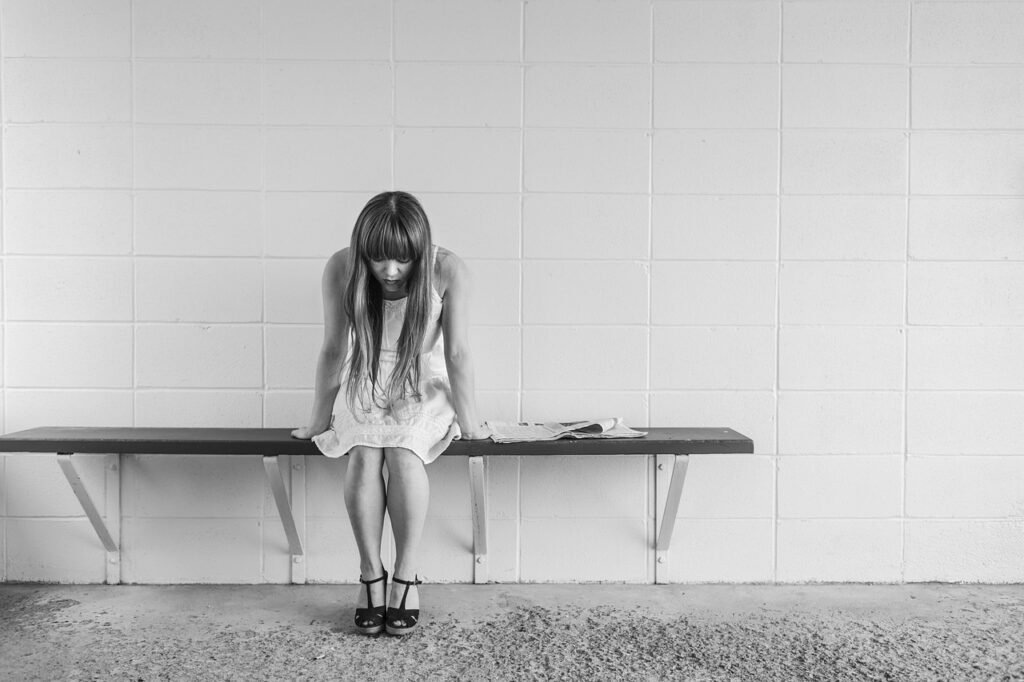 worried girl, woman, waiting, sitting, thinking, worry, black and white, sad, expression, people, person, depression, sadness, emotion, unhappy, adult, depressed, grief, frustration, despair, human, problem, stressed, young, sad girl, female, girl, long hair, dress, bench, concrete, wall